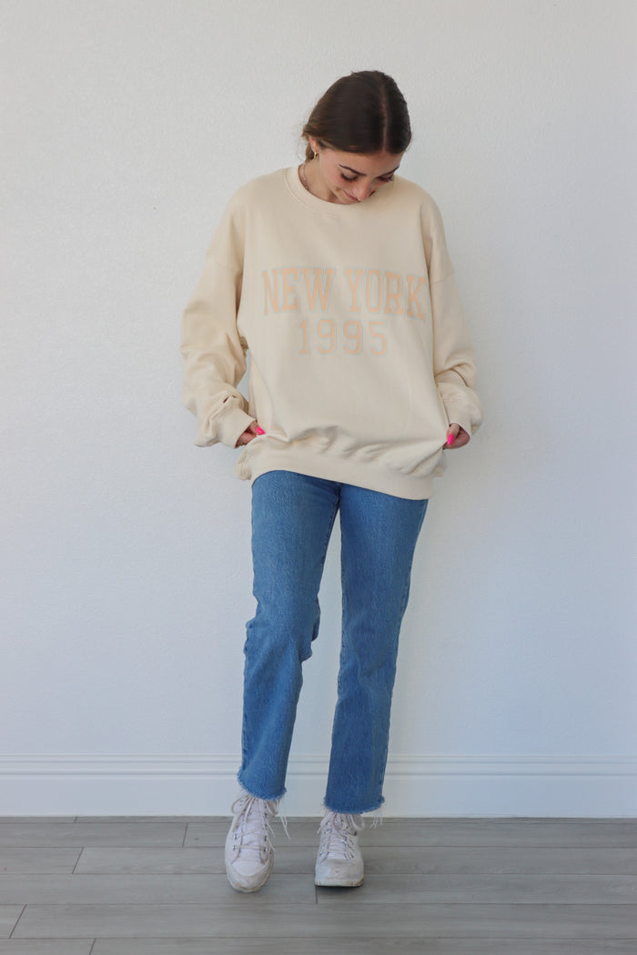 girl wearing cream "new york 1995" crewneck