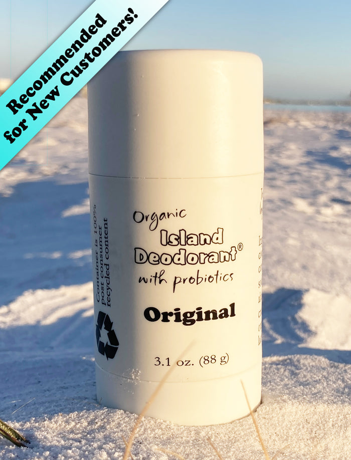 Organic deodorant stick with probiotics in recycled plastic container on beach background