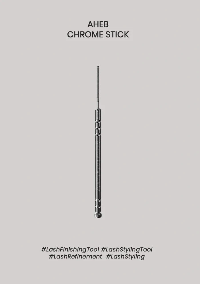 A single slim metallic lash styling tool is centered on a plain light gray background, with the text 'AHEB CHROME STICK' above it and hashtag-style labels below.