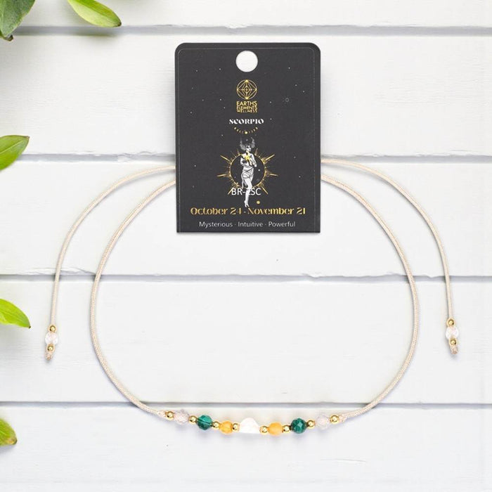 Necklace with Scorpio zodiac card on a white wooden background