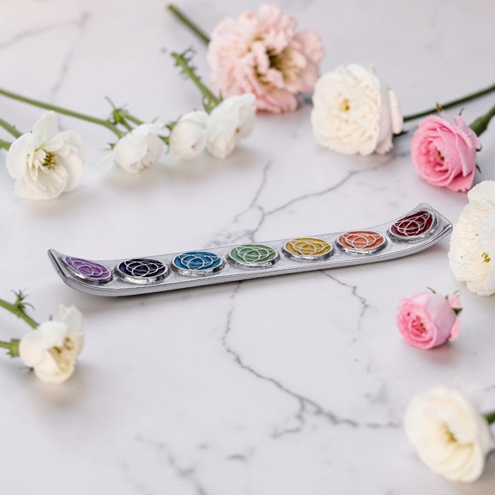 Celtic Trinity with Chakra Colors Incense Stick Burner with flowers around on a marble surface