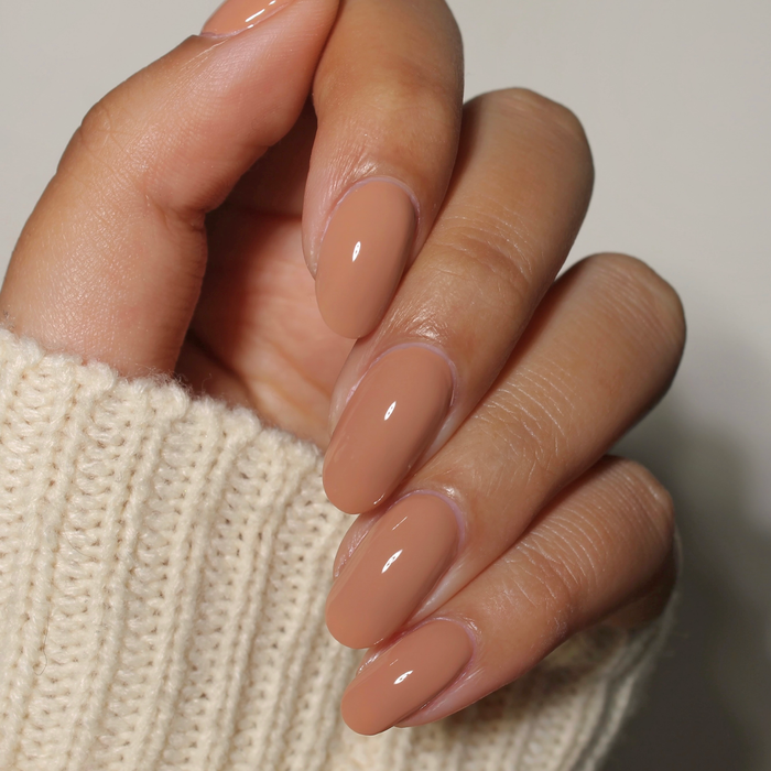 Choco-lot to Love dark tan nail polish manicure on a light skin tone with a white sweater