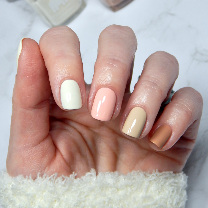 Choco-lot to Love tan with cream and peach mix-and-match manicure with a white sweater