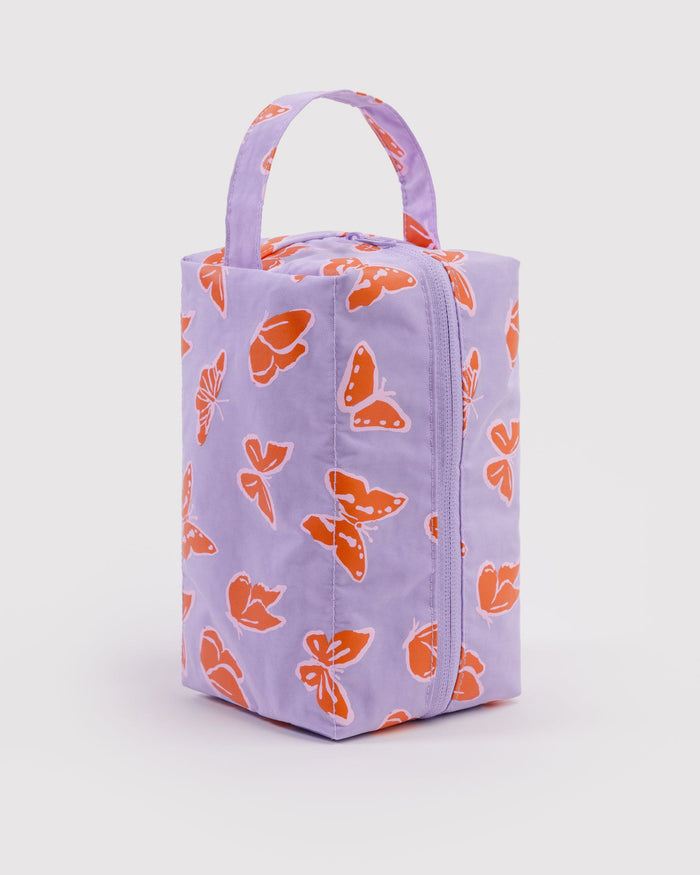 Dopp kit with lavender exterior and orange butterfly print, zip-top and carry handle