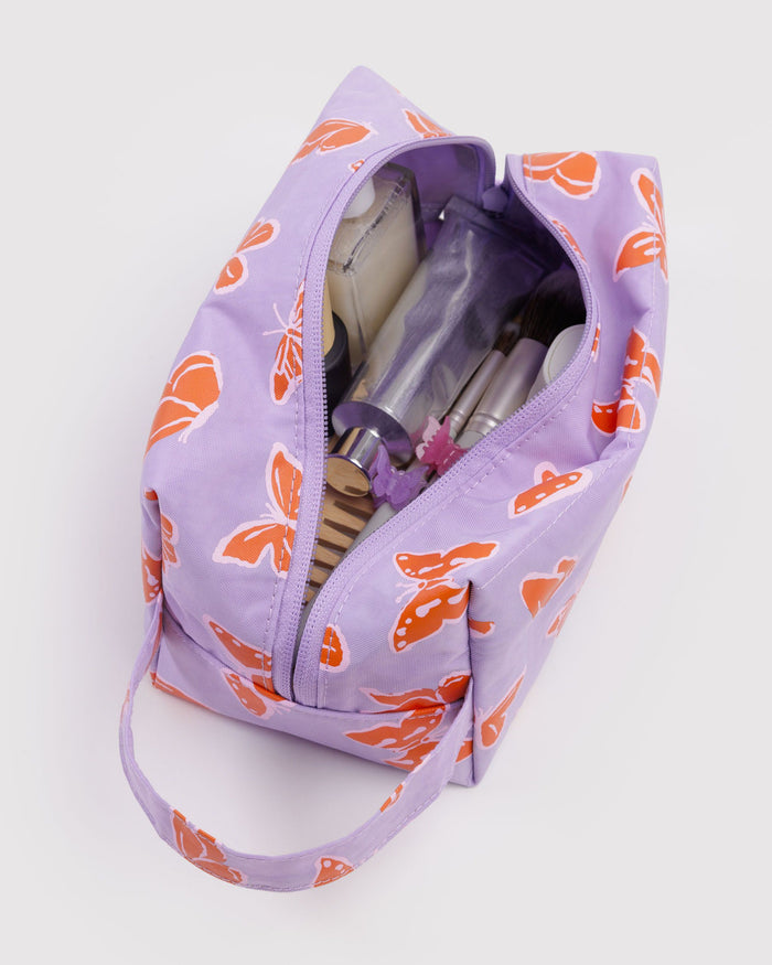 Dopp kit in lavender with orange butterfly print, open zip shows toiletries pockets