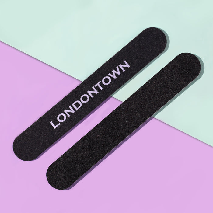 Two durable Emery Board Nail Files from LONDONTOWN are displayed on a pastel diagonal background, split between mint green and lavender. Perfect for everyday use at home or on the go in your purse.