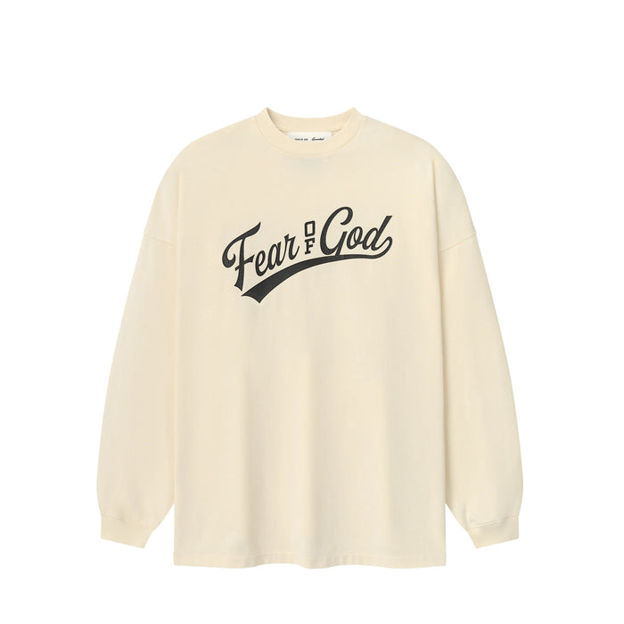 An oversized cream-colored long-sleeve t-shirt with 'Fear & God' printed in black script across the chest, displayed on a clean white background.
