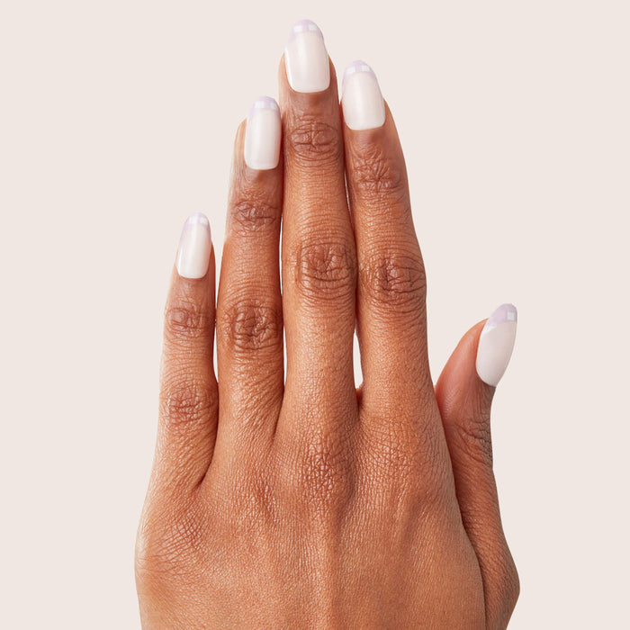 Hand displaying Gingham French - Press-On | Medium | Oval with neutral base and soft lavender gingham tips manicure