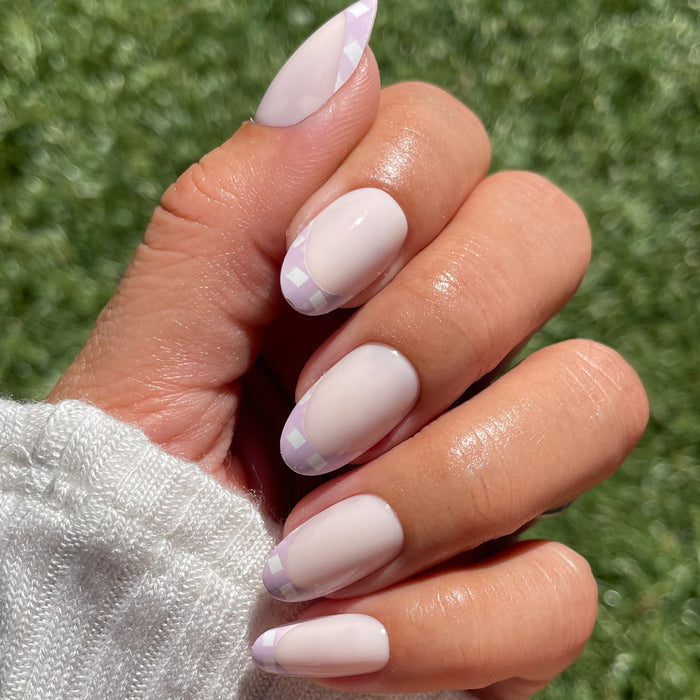 Hand showcasing Gingham French - Press-On | Medium | Oval with soft lavender gingham tips on medium oval nails manicure