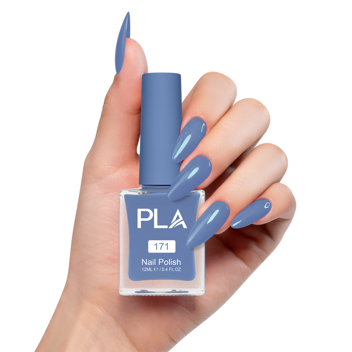 Hand holding a blue nail polish bottle with matching nails on a white background