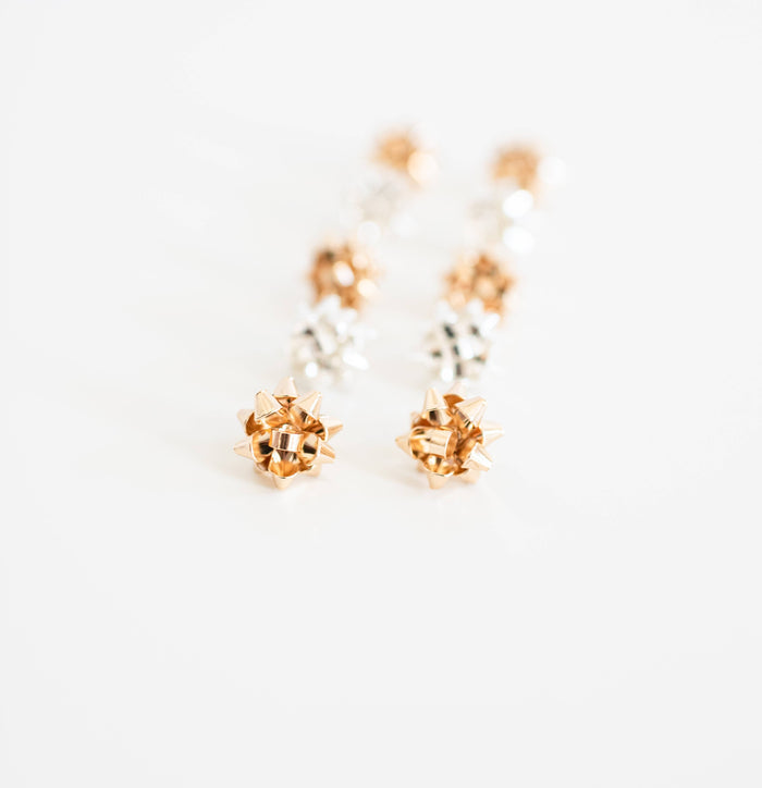 Gold Present Bow Earrings by St Armands Designs of Sarasota, featuring elegant bow-shaped earrings with a shiny gold finish.