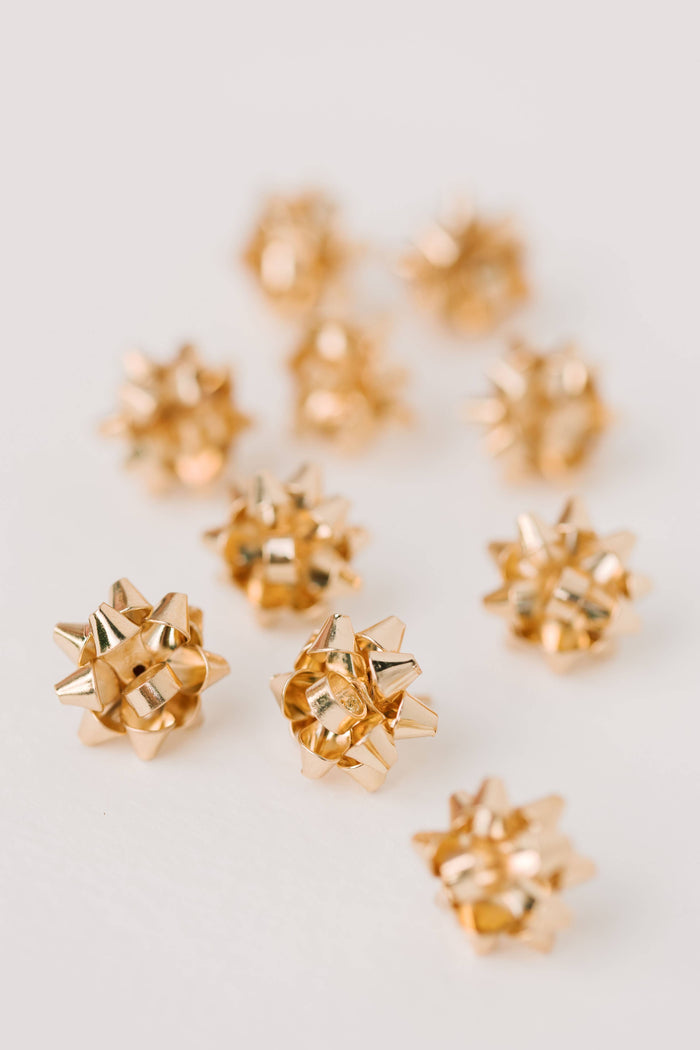 Gold present bow earrings by St Armands Designs of Sarasota, featuring festive gift bow-shaped jewelry with a shiny gold finish.