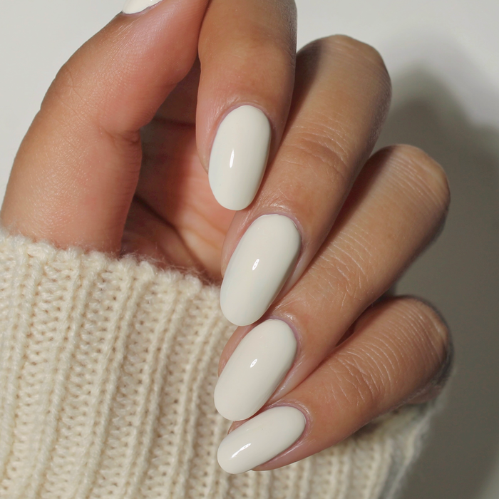 Icing on the Cake powder cream nail polish manicure on a medium skin tone with a white sweater