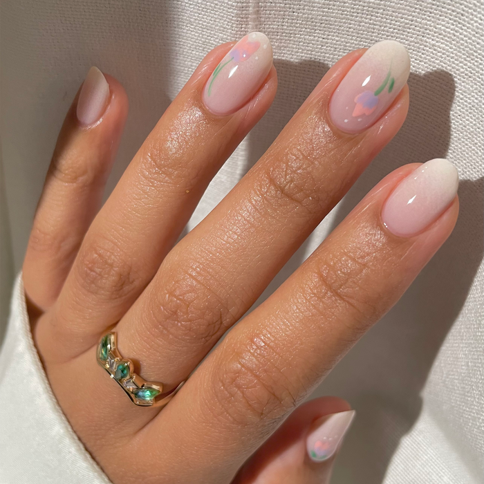 Icing on the Cake cream nail polish with tiny floral accents on a medium skin tone with a ring