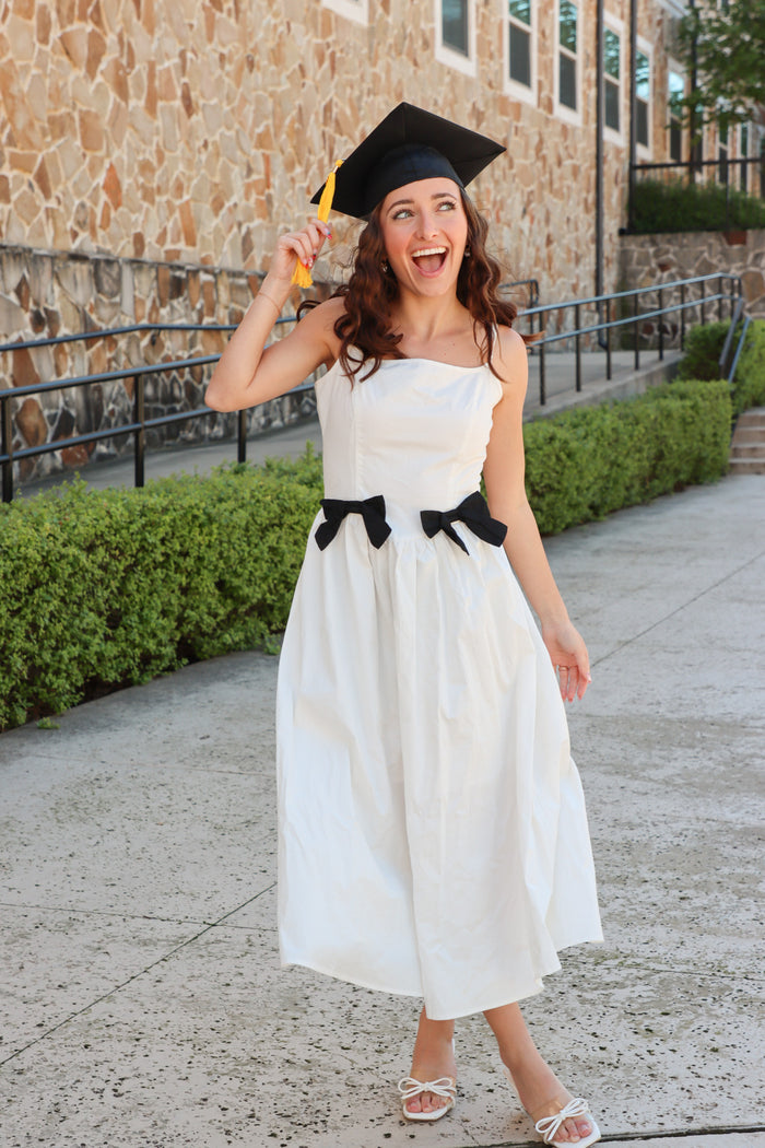 girl wearing white long dress with black bow details
