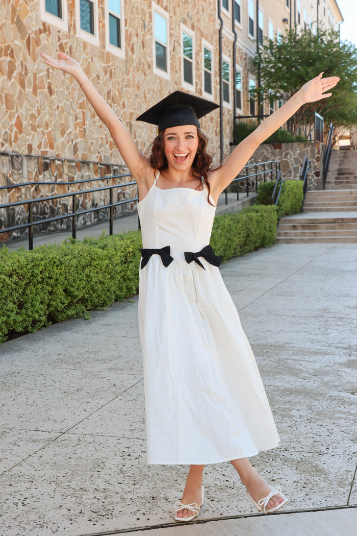 girl wearing white long dress with black bow details