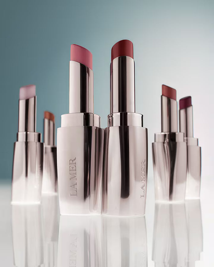 La Mer The Lip Treatment in various shades, new in box, featuring sleek packaging and natural lip color variations.