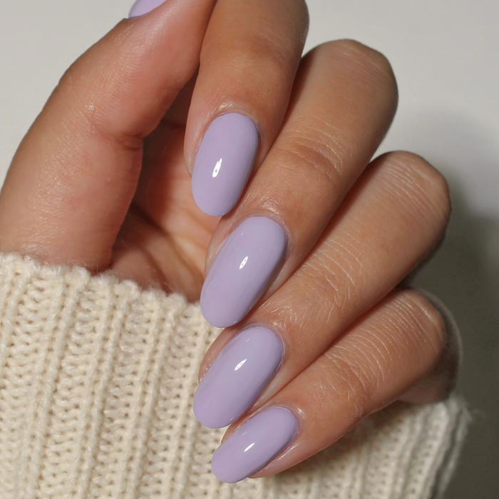 Lavender Drop pastel lavender nail polish manicure on a medium skin tone with a white sweater