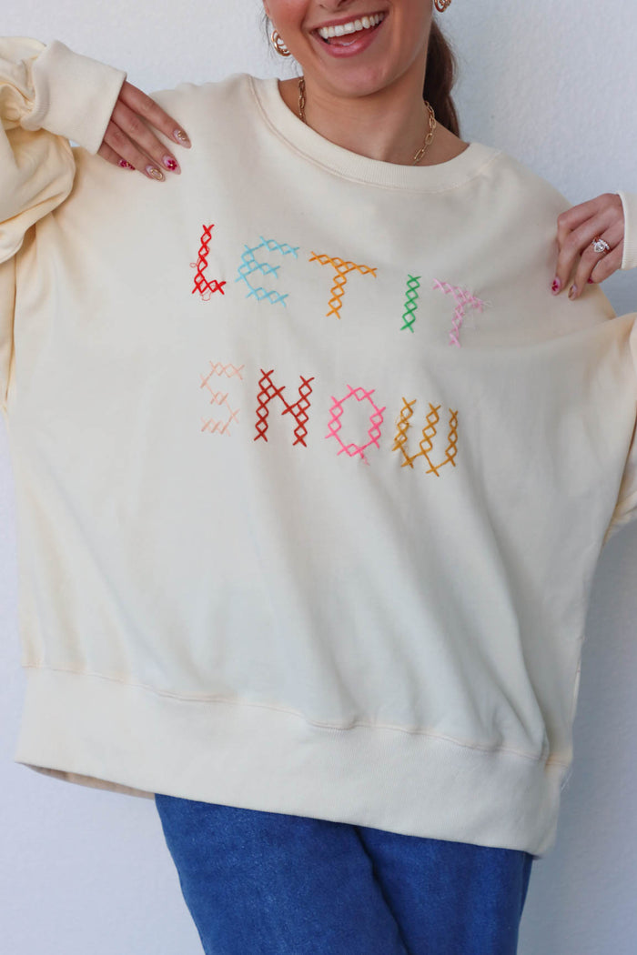 girl wearing cream "let it snow" top