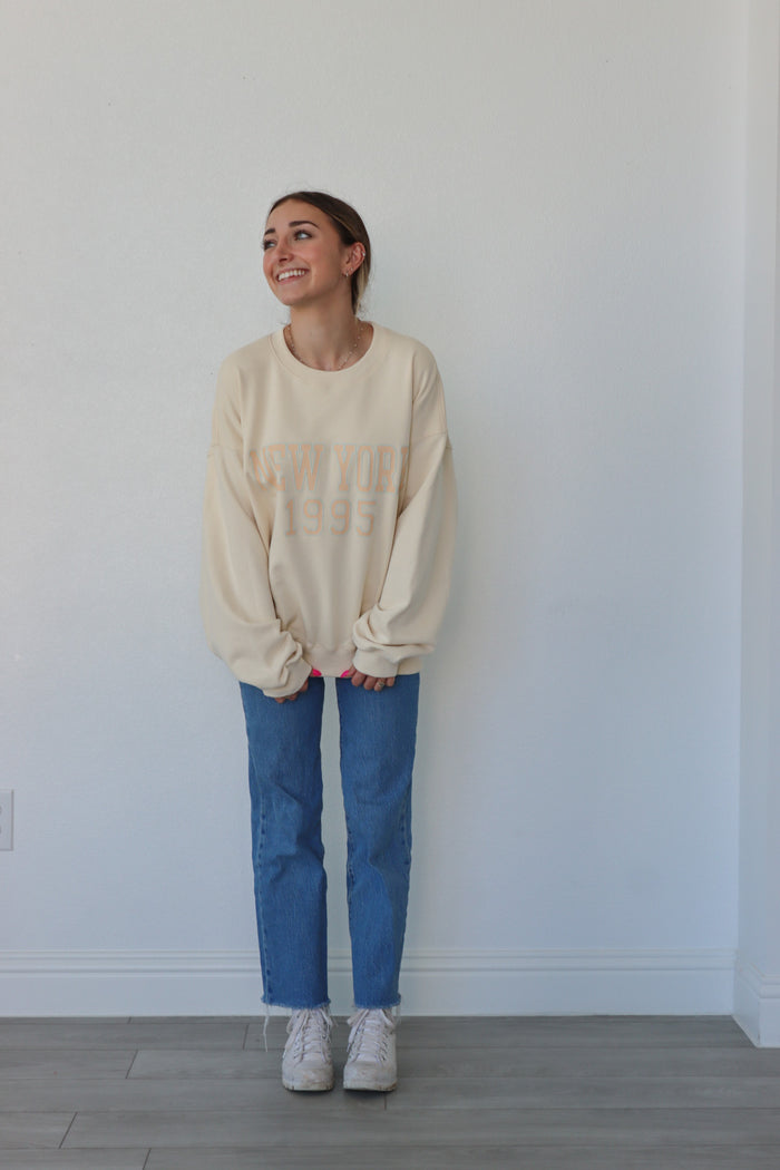 girl wearing cream "new york 1995" crewneck