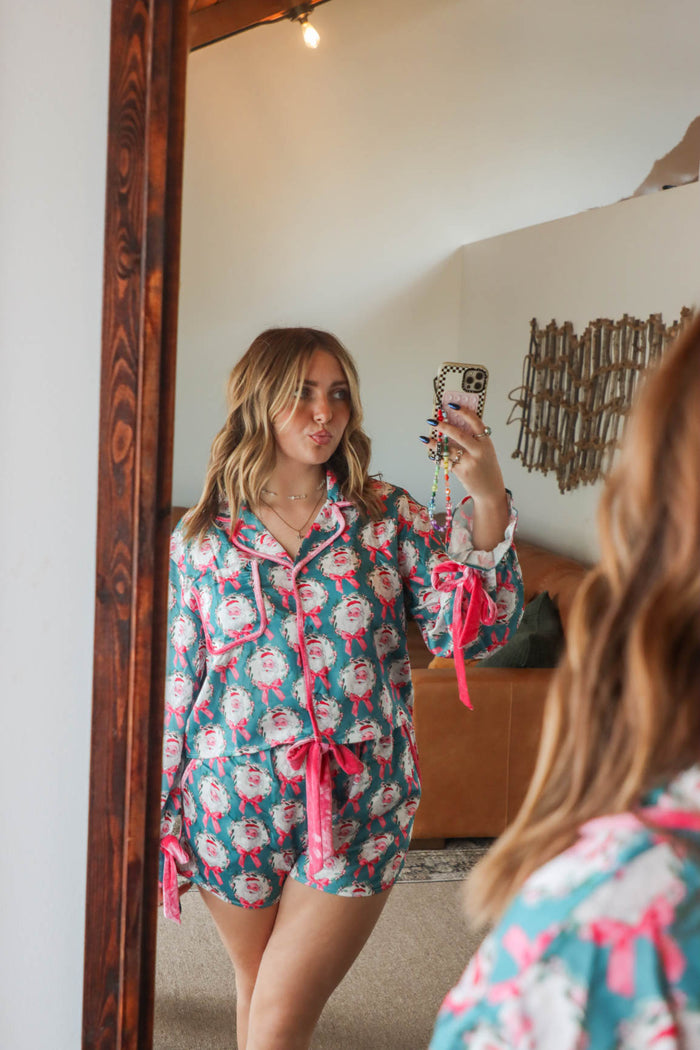 girl wearing teal and pink silk santa pajamas