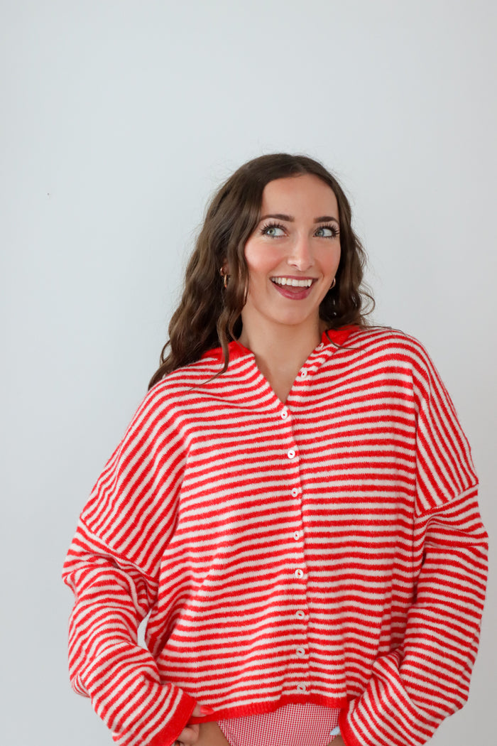 Woman wearing a red and white striped shirt against a plain background