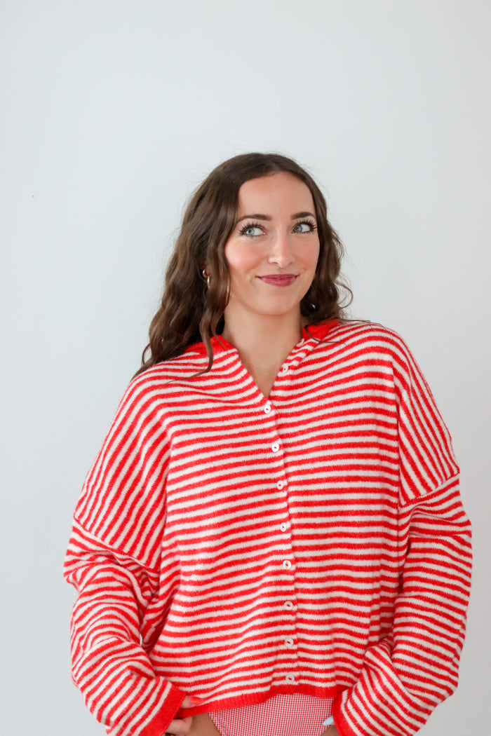 Woman wearing a red and white striped shirt against a plain background