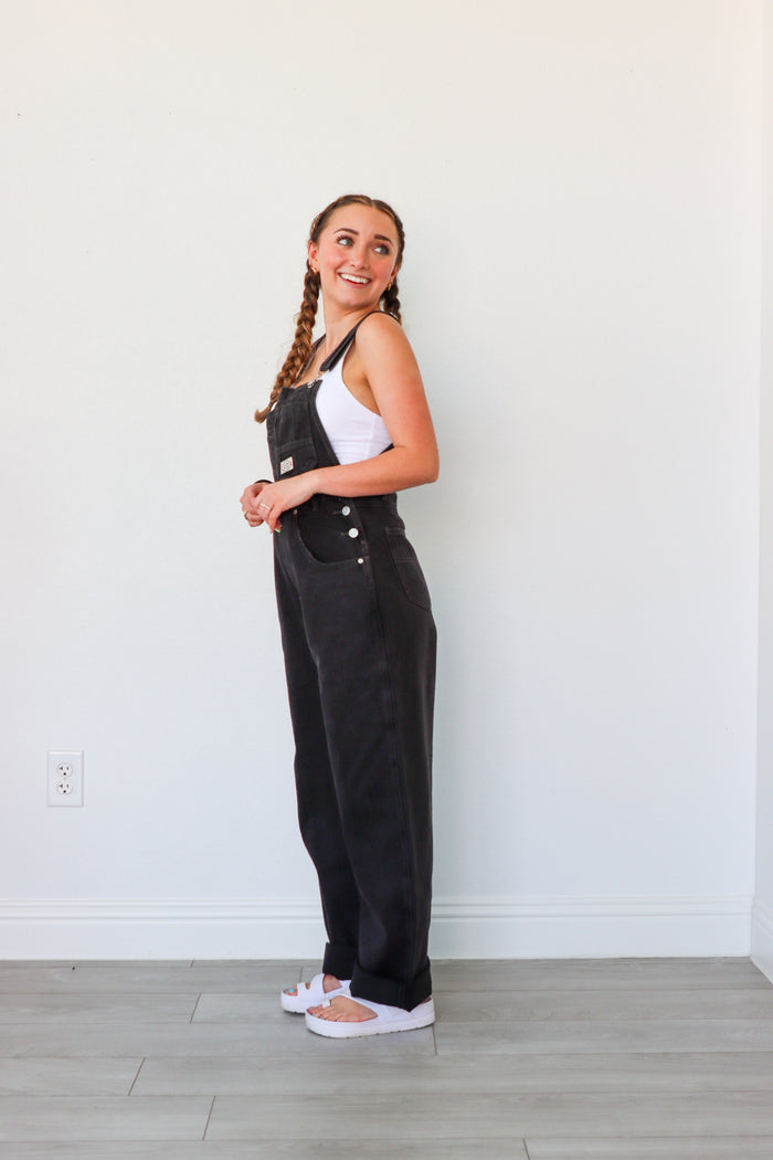 girl wearing black denim overalls