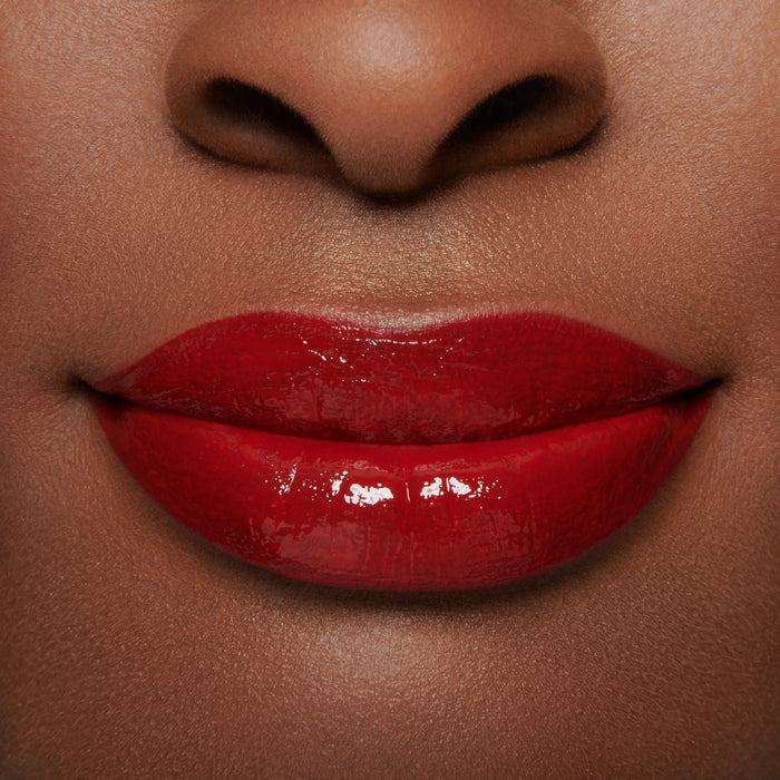 block1 red lip red lips red ribbon gloss embrace lip gloss containing wild mango kernel butter for lip benefits on model