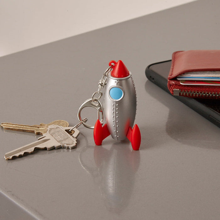 Rocket LED keychain with red nose, blue window, silver body, red fins, and keyring