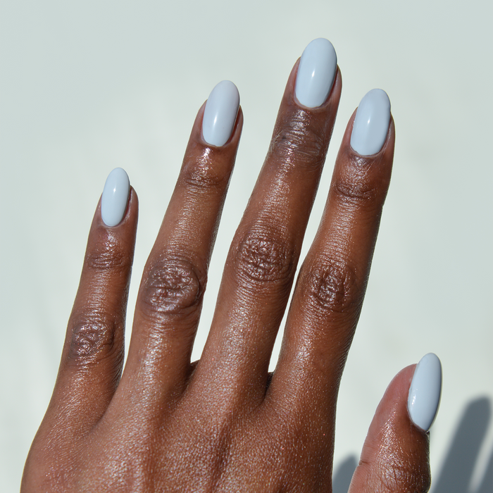 Royal Tea pastel grey-toned blue nail polish manicure on a deep skin tone