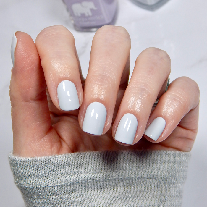 Royal Tea pastel blue nail polish manicure on a light skin tone with a white sweater