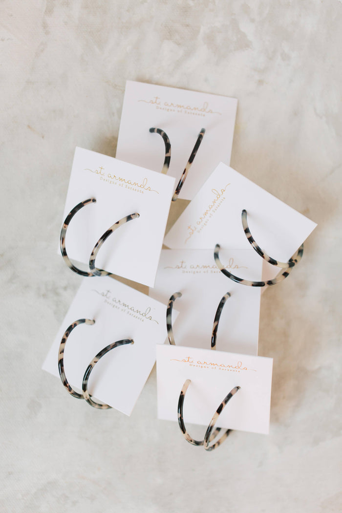 Skinny blonde tortoise hoop earrings by St Armands Designs of Sarasota, featuring lightweight, stylish gold-toned jewelry.