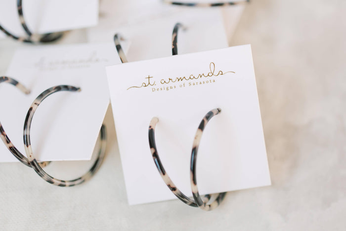 Skinny blonde tortoise hoop earrings from St Armands Designs of Sarasota, showcasing slim, stylish earrings with tortoise pattern.