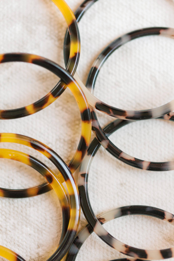 Skinny blonde tortoise hoop earrings from St Armands Designs of Sarasota, showcasing lightweight, stylish earrings with a tortoise pattern.