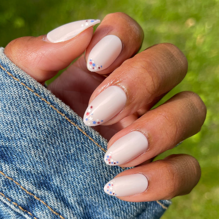 Star Showers | Almond | Medium press-on false nails with delicate red, white, and blue star French tips manicure