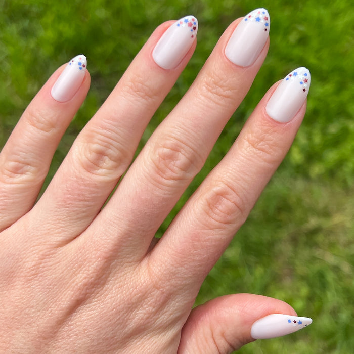 Star Showers | Almond | Medium press-on manicure with medium almond shape and tiny festive star French tips design