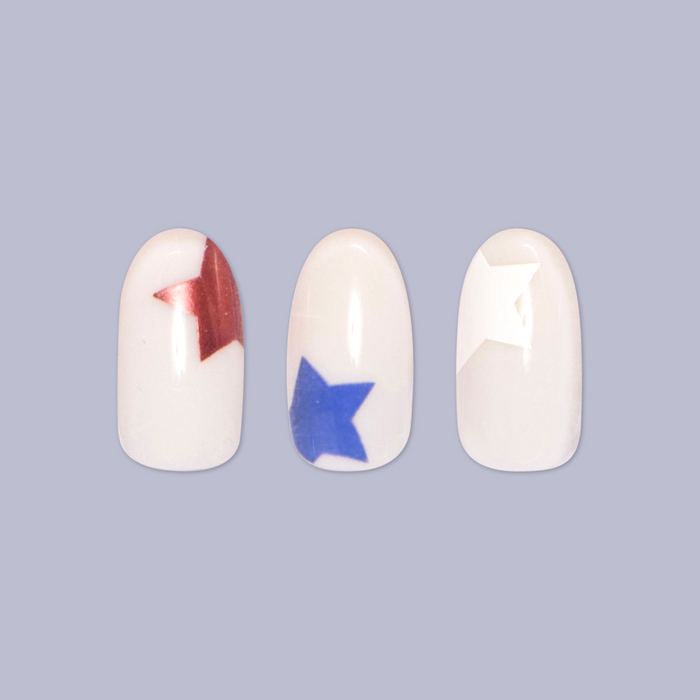 Super Festive Stars | Oval | Medium press-on nails with blue and metallic red star designs on neutral base in oval shape