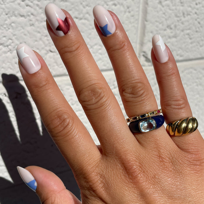 Super Festive Stars | Oval | Medium press-on nails with red, white, and blue star designs on neutral oval tips