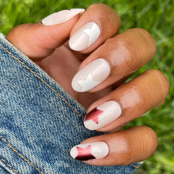 Super Festive Stars | Oval | Medium press-on nails with metallic red and blue stars on neutral oval false nails manicure