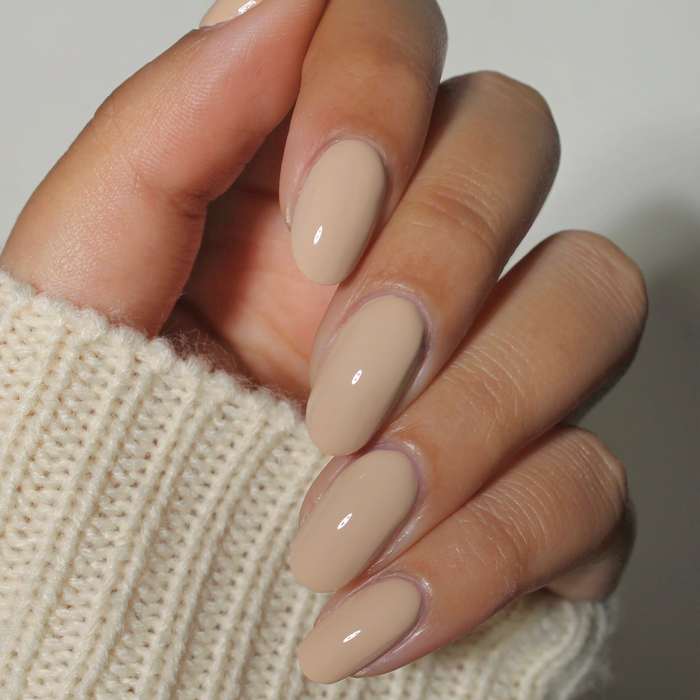 Whipped Chai pastel light tan nail polish manicure on a medium skin tone with a white sweater