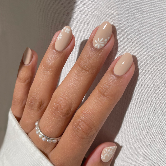 Whipped Chai light tan nail polish with white floral accent nails and a silver ring