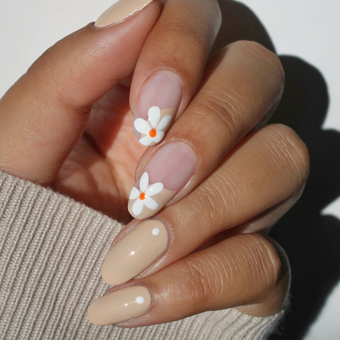 Whipped Chai light tan nail polish with white daisy accent nail art on a light skin tone