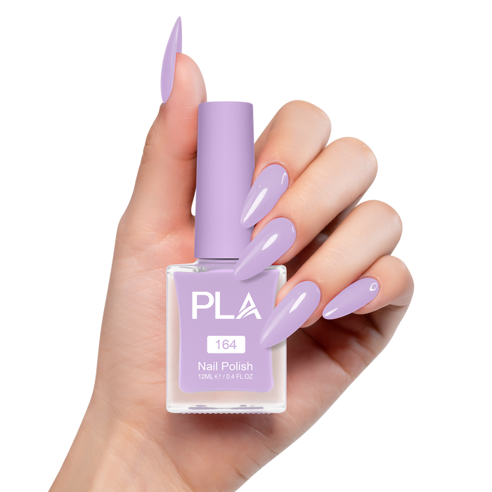 Hand holding a purple nail polish bottle with matching nails on a white background